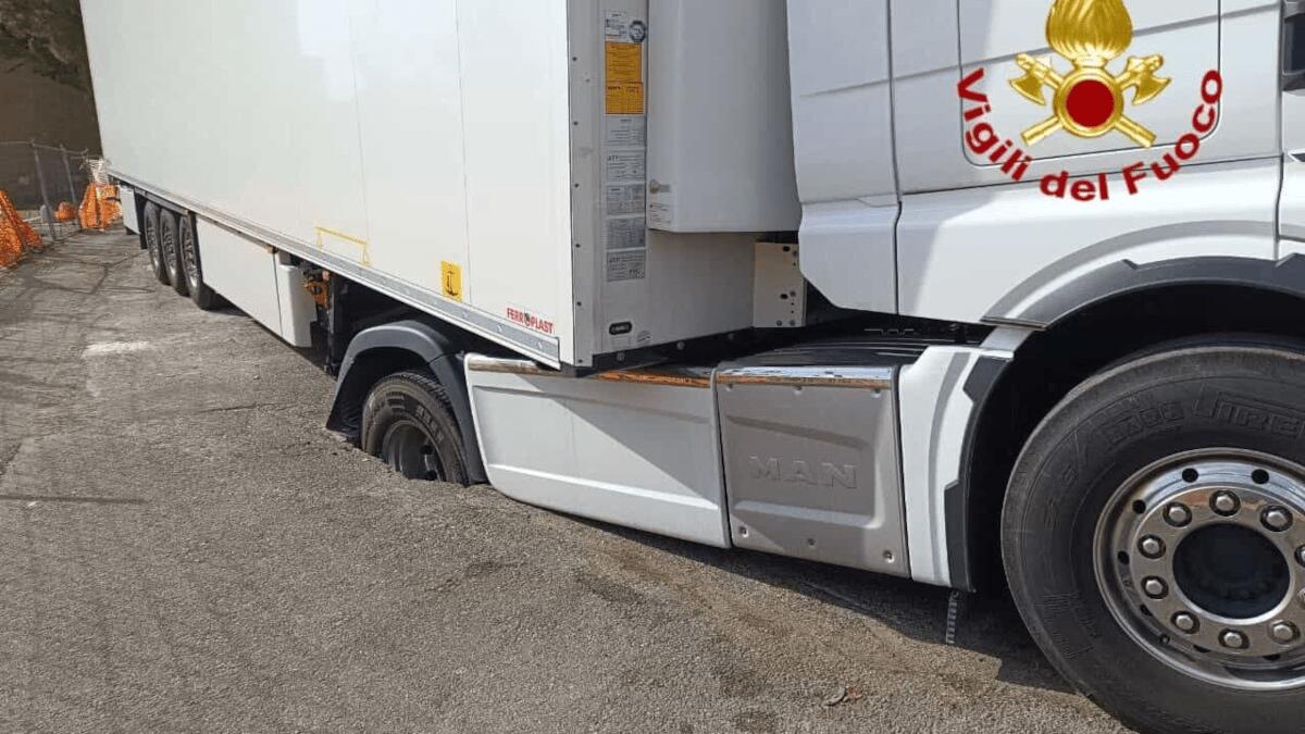 Voragine di oltre 10 metri “nascosta” dal manto stradale: Tir sprofonda pericolosamente - 